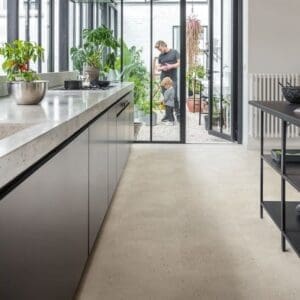 Kitchen with black cabinetry and Oyster Concrete flooring opening to garden area