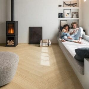 Cozy living space with fireplace and Quick-Step Alpha Ciro Pure Oak Blush flooring in herringbone pattern