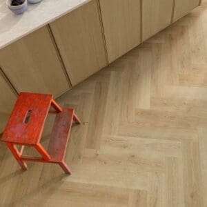 Quick-Step Alpha Ciro Botanic Beige Herringbone flooring in bedroom with person entering doorway