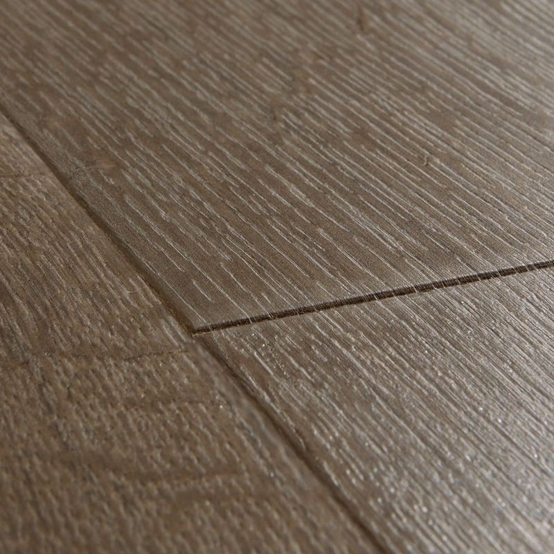 Close-up of Quick-Step Impressive Classic Oak Brown laminate flooring showing textured surface and plank connection