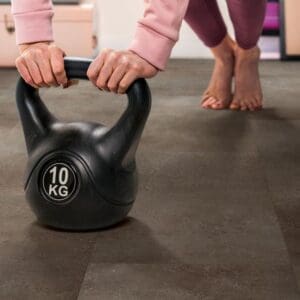 Quick-Step Alpha Oro Oxidized Rock vinyl flooring in a home gym setting with exercise equipment
