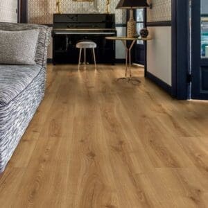 Quick-Step Desert Oak Warm Natural laminate flooring installed in a modern living room with black accent wall