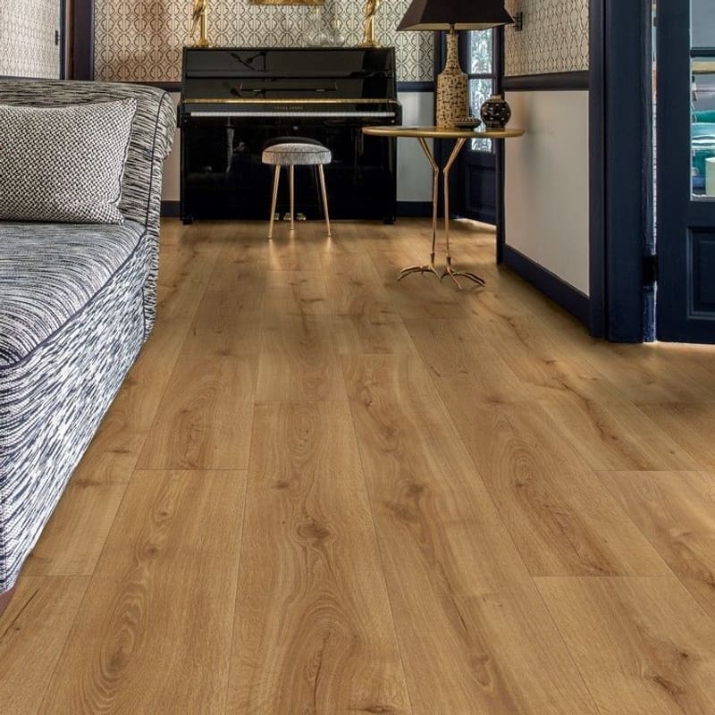 Quick-Step Desert Oak Warm Natural laminate flooring installed in a modern living room with black accent wall