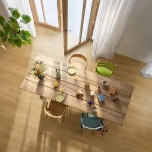 Family breakfast scene with dog on Quick-Step Alpha Bloom Brushed Oak Honey vinyl flooring