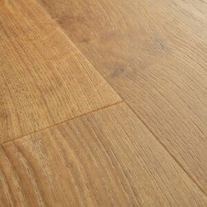 Close-up of Quick-Step Alpha Bloom Honey Oak vinyl flooring showing natural wood grain pattern and embossed texture