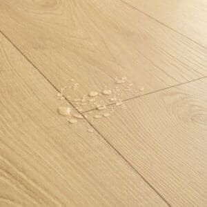 Close-up of Quick-Step Desert Greige Oak laminate flooring showing natural oak grain pattern