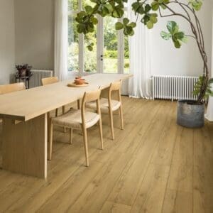 Bright dining room with honey oak laminate flooring and large indoor plant
