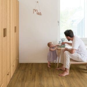 Cocoa Brown Oak laminate flooring in a bright room with wooden furniture