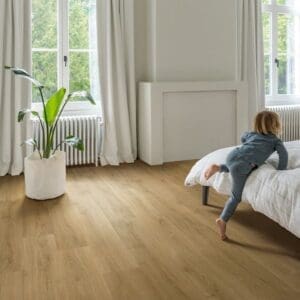 Quick-Step Capture Brushed Oak Warm Natural laminate flooring in a cabin with green accent wall