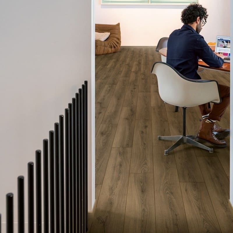 Modern home office with Quick-Step Warm Brown Oak laminate flooring and minimalist furniture