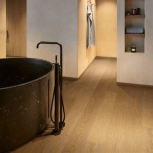 Detail view of Quick-Step Cocoa Oak vinyl flooring in bathroom setting showing plank joints and installation