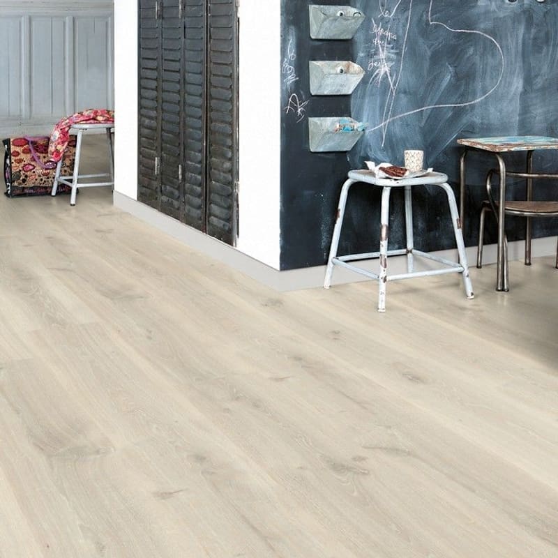 Quick-Step Tennessee Oak Grey laminate installed in a modern interior with black chalkboard wall