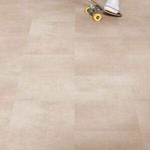 Person skateboarding on Quick-Step Alpha Oro Coral Rock vinyl flooring showing durability