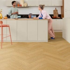 Quick-Step Alpha Ciro Pure Oak Honey vinyl flooring installed in modern kitchen with white cabinetry