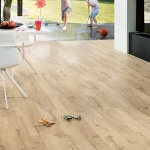 Modern living space with Quick-Step Impressive Classic Oak Beige laminate flooring and outdoor view
