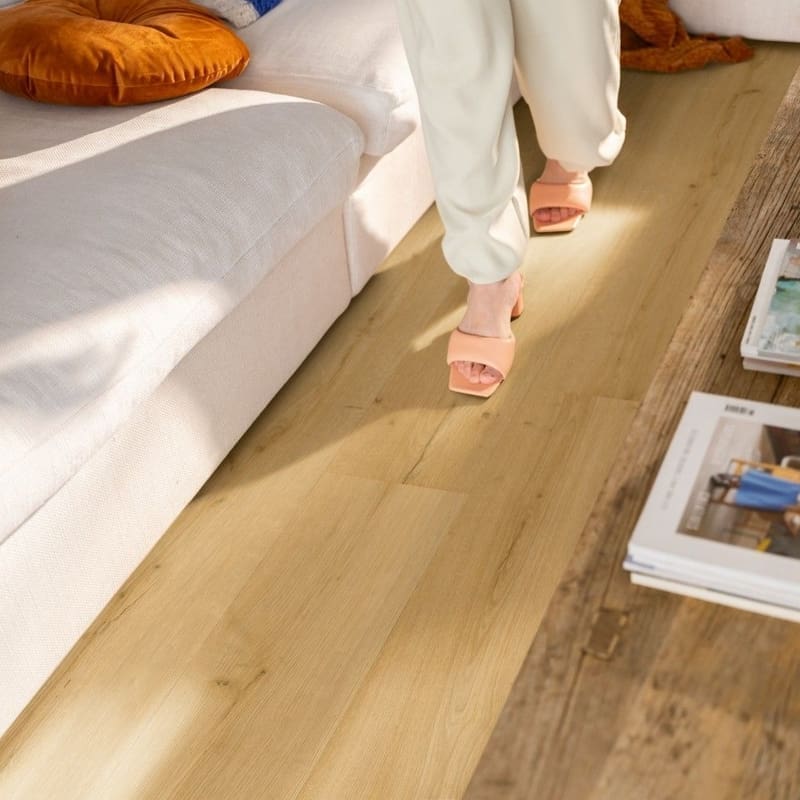 Close-up showing water resistance of Quick-Step Alpha Bloom Brushed Oak Honey vinyl flooring