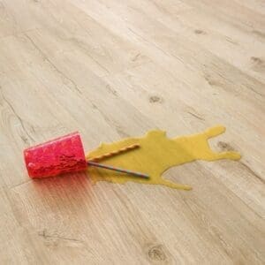 Quick-Step Impressive Ultra Classic Oak Beige laminate flooring with spilled drink demonstrating waterproof properties