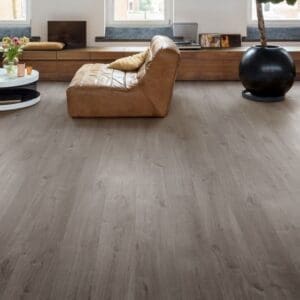 Bright living room with Cotton Oak Cozy Grey flooring, leather chair and indoor plant
