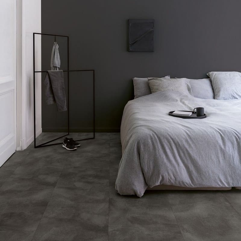 Quick-Step Soft Graphite vinyl flooring in a contemporary bedroom with minimalist decor