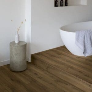Contemporary bathroom featuring Quick-Step Warm Brown Oak laminate flooring with freestanding bathtub