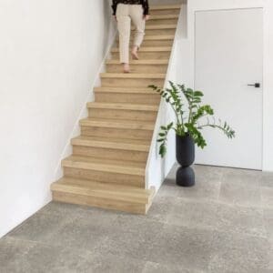 Person sitting on Quick-Step Raw Oak Laminate floor writing in notebook