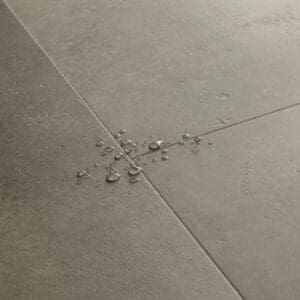 Water droplets on Quick-Step Cloudy Concrete flooring demonstrating waterproof properties