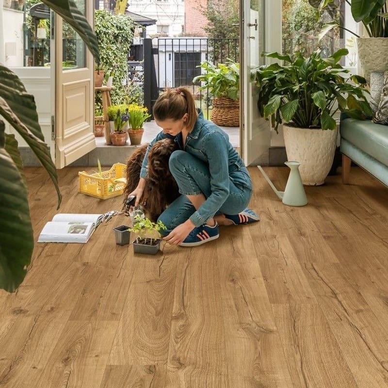Bright sunroom with plants featuring Quick-Step Impressive Classic Oak Natural laminate flooring