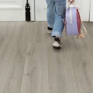 Child walking on Quick-Step Alpha Bloom Botanic Grey vinyl flooring showing durability for family homes