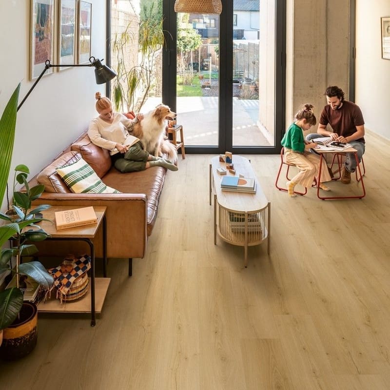 Feet standing on wet Quick-Step Alpha Bloom Brushed Oak Honey vinyl flooring showing water resistance