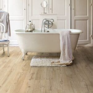 Elegant bathroom with freestanding bathtub on Quick-Step Impressive Classic Oak Beige laminate flooring