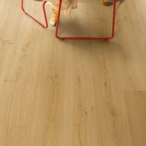 Child drawing at table on Quick-Step Alpha Bloom Brushed Oak Honey vinyl flooring