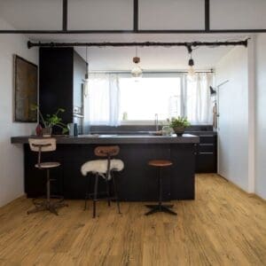 Modern kitchen with black island and Quick-Step Capture Cracked Oak Natural Laminate flooring