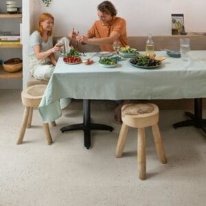 Quick-Step Oyster Concrete flooring in a dining area with natural light highlighting its subtle texture