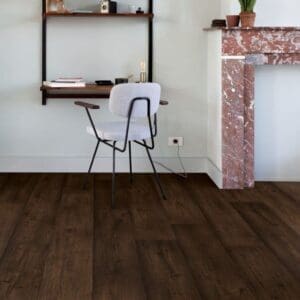 Home office space with Quick-Step Waxed Oak Brown laminate flooring featuring white walls and wooden furniture