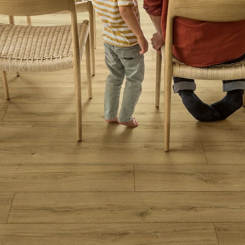 Close-up of chairs and child standing on honey oak laminate flooring