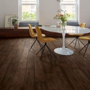 Dining room with Quick-Step Waxed Oak Brown laminate flooring featuring white walls and pendant lighting