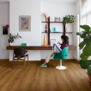 Home office workspace with Quick-Step Botanic Caramel Oak flooring and large fiddle leaf fig plant