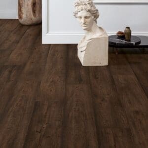 Living space with Quick-Step Waxed Oak Brown laminate flooring featuring white walls and decorative elements
