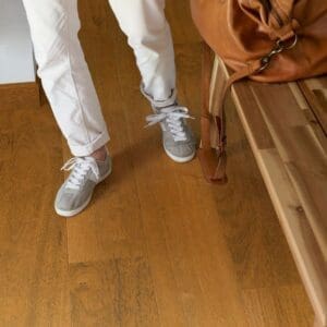 Quick-Step Capture Merbau SIG4760 laminate flooring installed in a modern living room with leather sofa and hanging chair