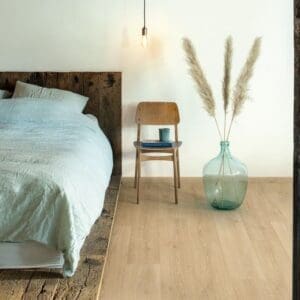 Quick-Step Alpha Bloom Botanic Beige vinyl flooring sample showing warm oak tones and natural grain pattern