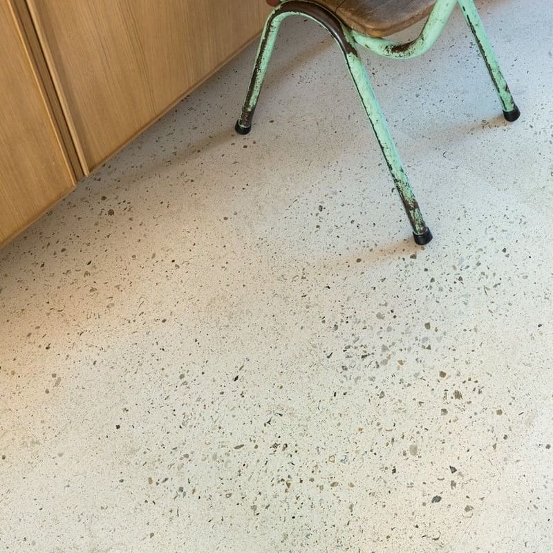 Close-up of child's feet on step stool with Quick-Step Pebble Concrete flooring