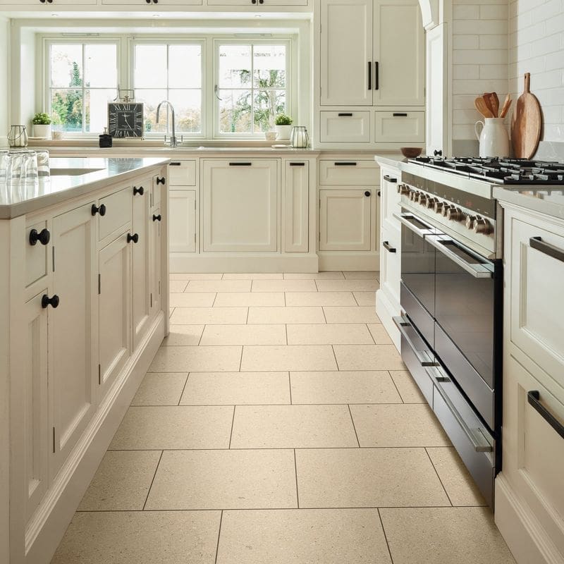 Ischia limestone pvt703 installed in kitchen with cream cabinets and stainless steel appliances