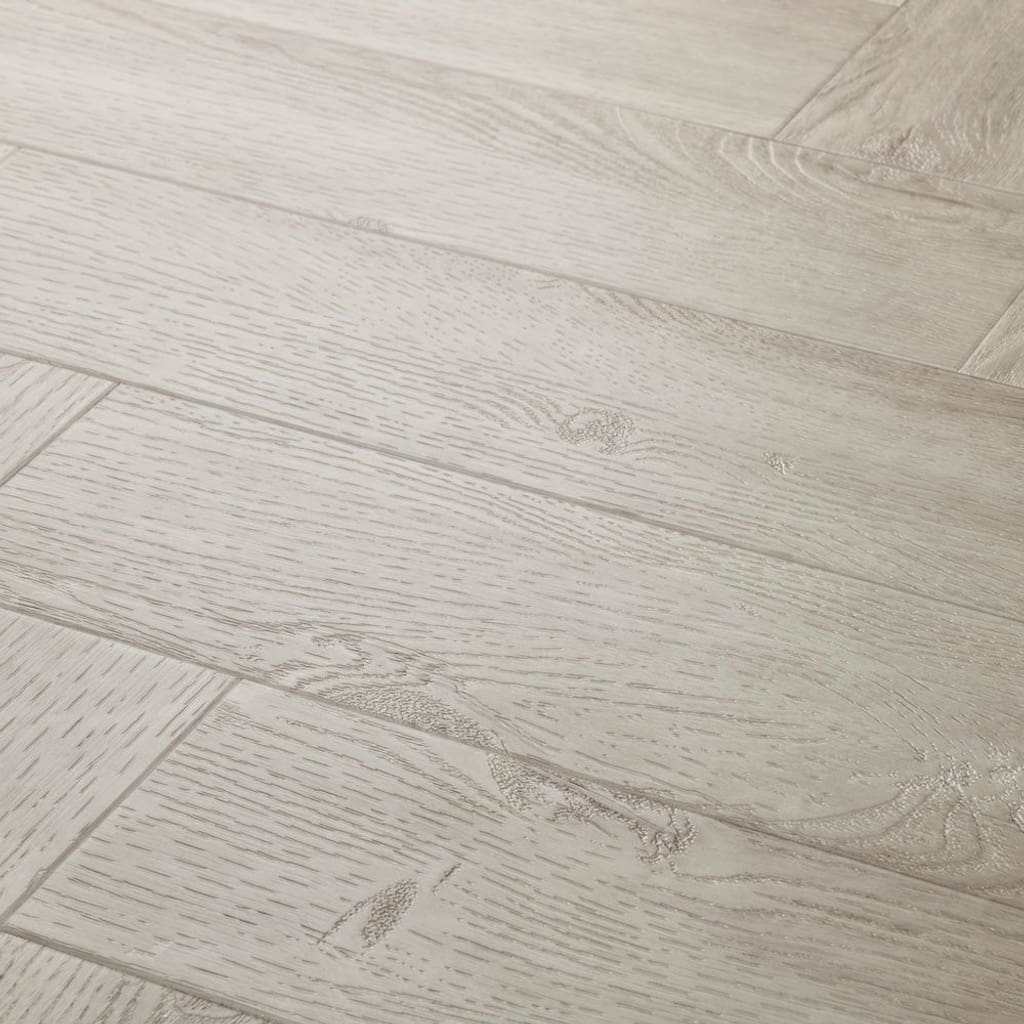 Close up of Elements Inspirations White Ash Herringbone EIH11 luxury vinyl flooring showing wood grain detail.