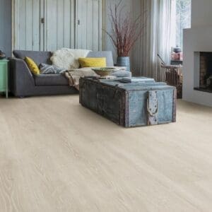 Living room with Quick-Step Majestic Woodland Oak Light Grey laminate flooring installed, featuring rustic furniture and wooden ceiling beams