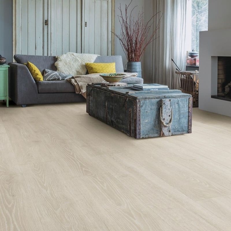 Living room with Quick-Step Majestic Woodland Oak Light Grey laminate flooring installed, featuring rustic furniture and wooden ceiling beams