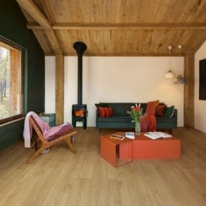 Quick-Step Capture Brushed Oak Warm Natural laminate flooring in a bedroom with child on bed