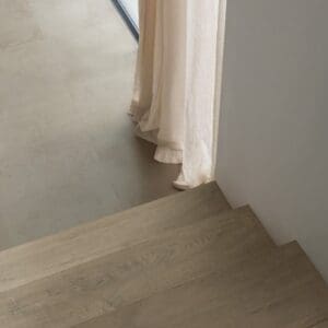 Cat walking on Quick-Step Grey Concrete Laminate flooring with children's bike
