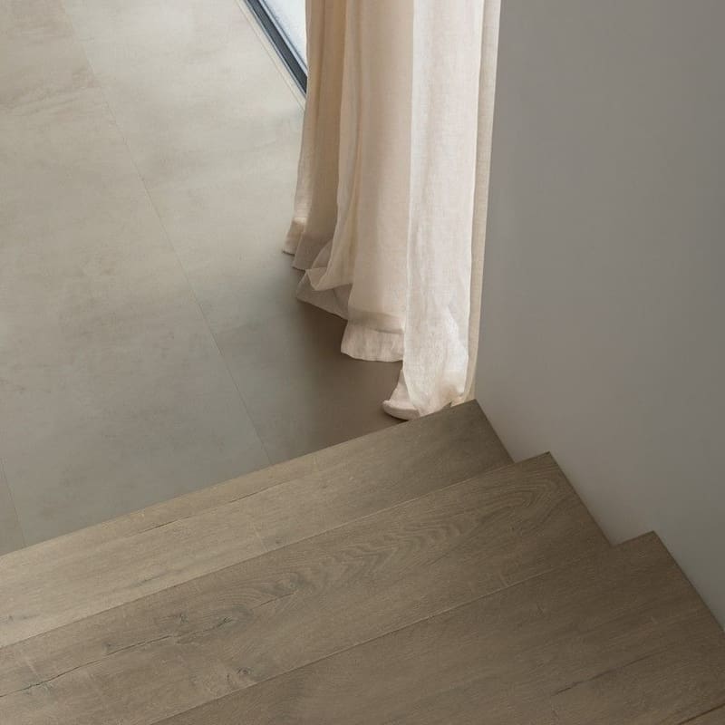 Cat walking on Quick-Step Grey Concrete Laminate flooring with children's bike