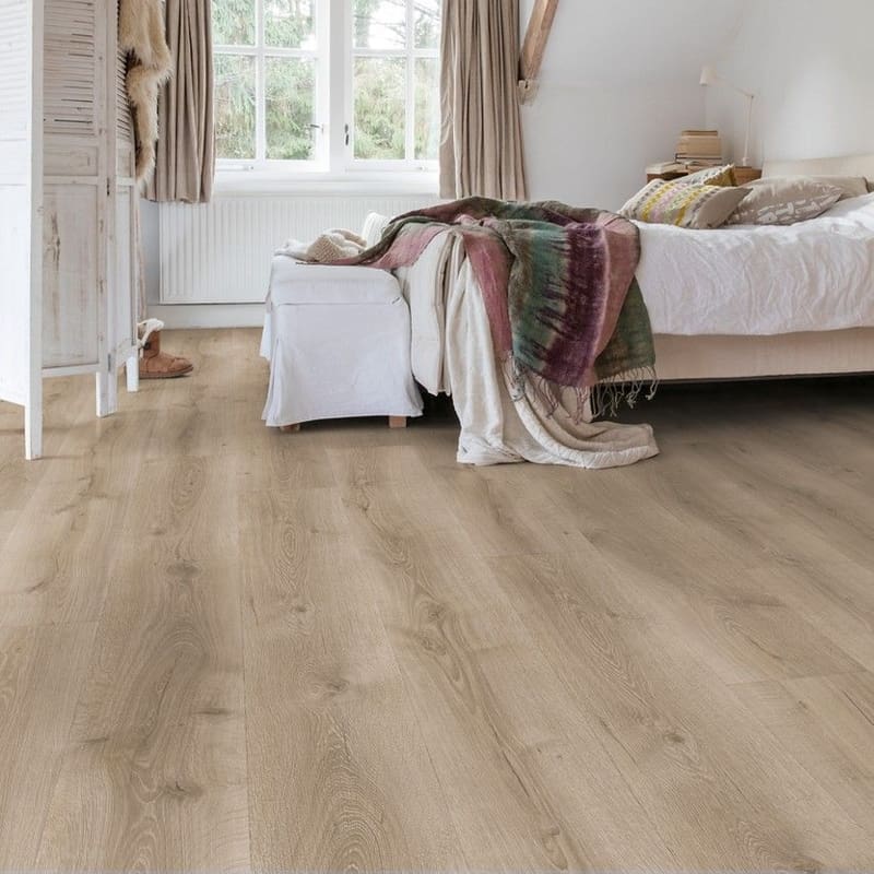 Bedroom with Quick-Step Majestic Desert Oak Brushed Grey laminate flooring installed, showing the flooring in a real-world setting
