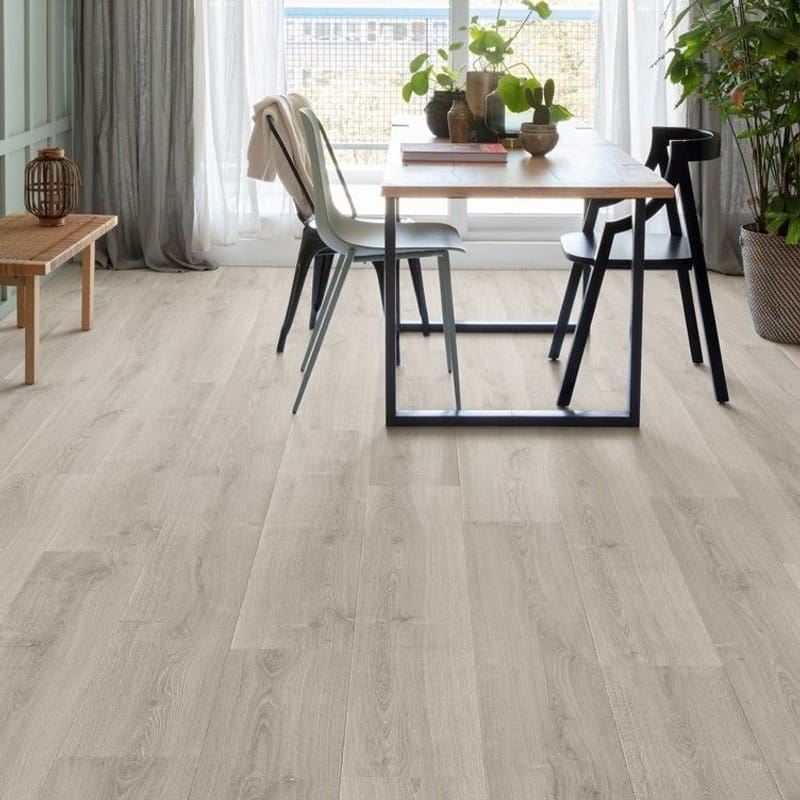Living room with Quick-Step Capture Brushed Oak Grey laminate flooring featuring a wooden bench and pendant lights